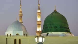 al mashed al nabawi Green Dome and white dome with minarets at a mosque against evening sky.