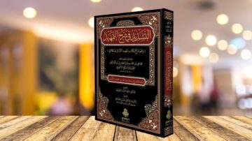 كتاب الشفاء في أحكام الطهارة للشيخ عبد الله بن محمد بن عبد الوهاب، يظهر على طاولة خشبية مع خلفية مضيئة. الكتاب مزين بغلاف ملون بألوان دافئة ونقوش تقليدية.