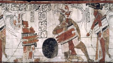 رسم جداري يوضح مشهداً من لعبة كرة القدم القديمة، يُظهر ثلاثة رجال يرتدون أزياء تقليدية، أحدهم يحمل درعاً، بينما الآخرون يتفاعلون حول كرة كبيرة. الخلفية مزينة بنقوش ورموز مميزة تعكس الثقافة القديمة.