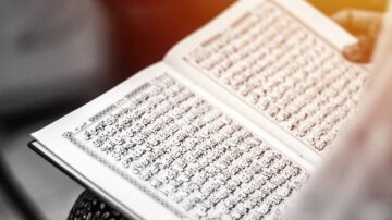 كتاب مفتوح بلغة عربية، يحتوي على نصوص دينية مكتوبة بخط جميل، مع تفاصيل دقيقة على الصفحات.