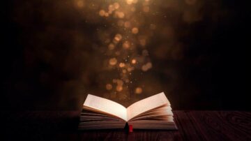 كتاب مفتوح على طاولة خشبية، مع بريق ذهبي يتصاعد من الصفحات، مما يخلق جوًا سحريًا.