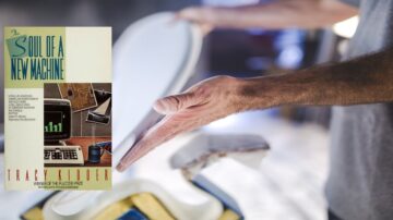 غلاف كتاب "روح آلة جديدة" لترايسي كيدر، يظهر في مقدمة الصورة مع يد تمسك بجهاز كمبيوتر قديم في خلفية ضبابية. الكتاب يركز على تطور التكنولوجيا وتأثيرها على المجتمع.