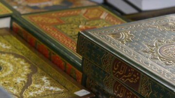 مجموعة من المصاحف الملونة، تضم تصاميم غنية وزخارف دقيقة، مع التركيز على المصحف الأخضر الذي يظهر في المقدمة.