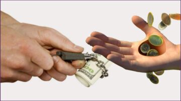 يد تُمسك بسلسلة مرتبطة برزمة من الدولارات، بينما يد أخرى مفتوحة تتلقى عملات معدنية تتساقط. تعكس الصورة مفهوم تبادل المال والقيمة.