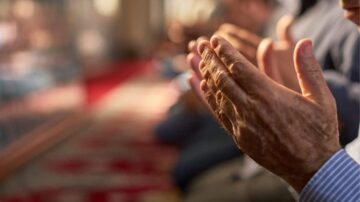 أيدي أشخاص كبار في السن تتصافح في جلسة جماعية، مع التركيز على التفاصيل الدقيقة للجلد والتجاعيد، في بيئة تقليدية.