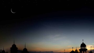 غروب شمس جميل مع هلال في السماء و silhouetted مآذن لمساجد، خلفية مظلمة مع نجوم متلألئة، يعكس أجواء السكون والروحانية.