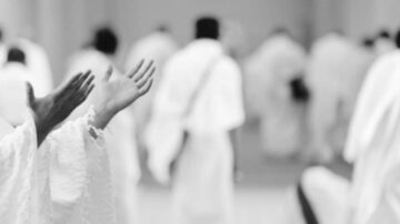 أيد مرفوعة في الصلاة مع أشخاص يرتدون ملابس بيضاء في الخلفية، مشهد يعكس روحانية العبادة والتركيز في الصلاة.