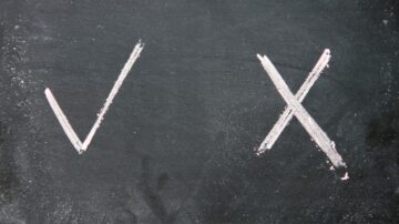 علامات صح وخطأ مرسومة على لوح أسود، علامة صح على اليسار وعلامة خطأ على اليمين.