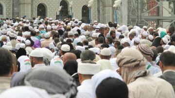 حشود كبيرة من المصلين في المسجد الحرام بمكة المكرمة، يرتدون ملابس تقليدية وعمائم، أثناء تأدية شعائر الحج أو العمرة.