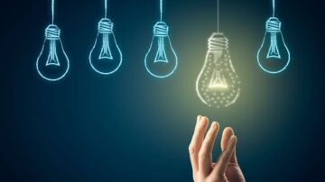 يد تظهر وكأنها تمتد نحو مصباح مضيء متصل بخيوط مضيئة، محاطة بمصابيح أخرى غير مضيئة. يرمز التصميم إلى الأفكار والإلهام والابتكار.