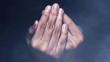 يدان متشابكتان مع بشرة ناعمة، يظهر عليهما بعض التفاصيل الدقيقة، محاطة بضباب خفيف، تعكس إحساسًا بالهدوء والتركيز.