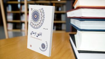 كتاب "المفتاح الإسلامي" يظهر في المقدمة، مع تصميم غلاف مزخرف بألوان زاهية. في الخلفية، تتواجد مجموعة من الكتب المكدسة، مما يبرز بيئة مكتبية. الكتاب يتناول مواضيع إسلامية مهمة.