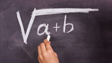 صورة ليد تكتب معادلة رياضية على سبورة سوداء باستخدام طباشير بيضاء. المعادلة تتضمن الجذر التربيعي لـ (α + b).