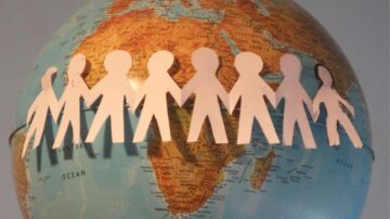 ورقة ملونة على شكل أشخاص متصلين بأيديهم توضع حول كرة أرضية تظهر قارة أفريقيا والمحيطات، ترمز إلى الوحدة والتعاون العالمي.