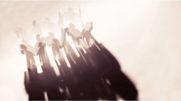 ظل مجموعة من الأشخاص المصنوعين من الورق، يظهرون بشكل مموه على خلفية فاتحة، مما يعكس شعوراً بالتضامن أو الوحدة.