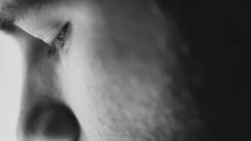 صورة قريبة لعين وشكل وجه رجل، تظهر تفاصيل البشرة بوضوح. تركز الإضاءة على ملامح الوجه، مما يبرز عمق التعبير والعواطف.