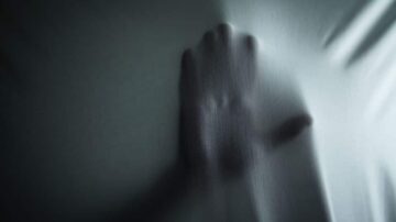 يد ممدودة تظهر من خلف قماشة مشدودة، مع وجود تأثيرات ضوء وظل تعزز الإحساس بالغموض والعمق.