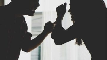 شخصان يتنافسان في مصارعة الذراعين، مع إضاءة خلفية تبرز ظلهما. تعبيرات الوجه تظهر التحدي والمرح.