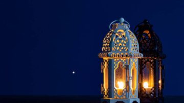 فوانيس مزخرفة باللونين الأبيض والأسود مضاءة في ظلام الليل، مع نجم ساطع في الخلفية.