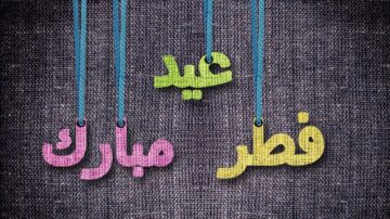 خلفية من القماش مع كلمات مكتوبة بألوان زاهية: "عيد" باللون الأخضر، و"مبارك" باللون الوردي، و"فطر" بالأصفر، تتدلى من خيوط زرقاء.
