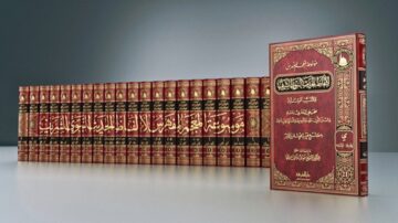 مجموعة من الكتب الإسلامية المغلّفة باللون الأحمر، مرتبة بشكل منتظم، مع كتاب بارز في المقدمة يحمل عنوانًا ذهبيًا. الكتب تبرز التراث الثقافي والديني، وتظهر تفاصيل فنية دقيقة على الغلاف.