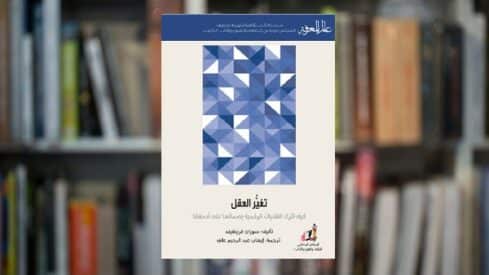غلاف كتاب "تغيّر العقل" بتصميم هندسي أزرق وأبيض على خلفية مكتبة.