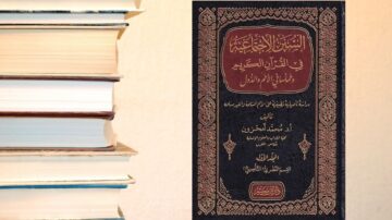 كتاب يتناول السيرة النبوية، مع غلاف مزخرف بالألوان الداكنة، محاط بمجموعة من الكتب المكدسة. يبرز الكتاب كمرجع في التاريخ الإسلامي.