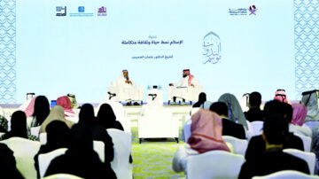 جلسة حوارية في مؤتمر ثقافي يتحدث فيها الشيخ الدكتور عثمان الخميس، بحضور جمهور متنوع من الرجال والنساء. يظهر المتحدثون على منصة مع لافتات تحمل شعارات الجهات المنظمة.