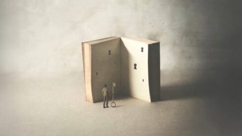 رجل صغير يقف أمام كتاب مفتوح يحتوي على أقفال، ممسكًا بمفتاح كبير، مما يرمز إلى استكشاف المعرفة والخيال.