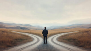 Person standing at a crossroads in a rural landscape, with two diverging paths surrounded by golden fields and distant mountains under a cloudy sky. The scene symbolizes decision-making and life choices.