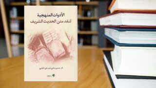 كتاب "الأدوات المنهجية لنقد متن الحديث الشريف" لأحمد حسن القاضي، يظهر على طاولة خشبية مع كتب أخرى في خلفية مكتبة. الكتاب يتناول أساليب نقد الأحاديث النبوية.