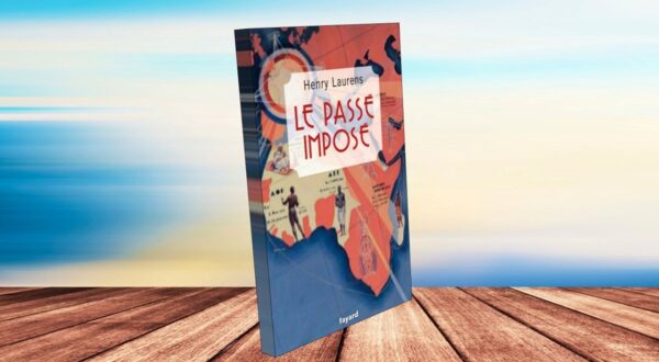 غلاف كتاب "Le Passe Imposé" للكاتب هنري لورانس، يظهر الكتاب بشكل ثلاثي الأبعاد على سطح خشبي، مع خلفية سماء زرقاء. يتضمن التصميم خريطة توضح مناطق جغرافية، مما يعكس موضوع الكتاب.