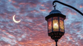 Ornate lantern casting a warm glow against a dramatic sky at dusk, featuring wispy clouds and a crescent moon, creating a serene and enchanting atmosphere.