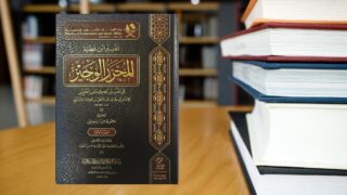 كتاب يتحدث عن تفسير القرآن الكريم، مع غلاف فخم باللون الأسود وعنوان بارز بالذهبي. يظهر الكتاب بجانب مجموعة من الكتب الأخرى على طاولة خشبية.
