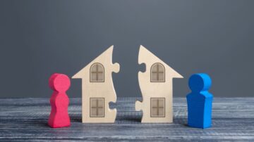 تمثيل رمزي لعملية تقسيم الممتلكات خلال الطلاق، حيث يظهر منزلين خشبيين متصلين بقطع بازل، مع شخصية حمراء وأخرى زرقاء تمثل الزوجين.