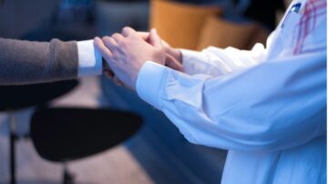 يدين تتصافح في بيئة مهنية، تعبير عن التعاون أو الاتفاق. يظهر التركيز على التواصل الإيجابي بين الأفراد.