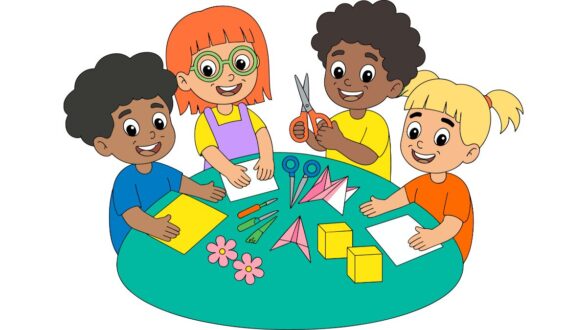 أربعة أطفال يجلسون حول طاولة مستديرة، يتشاركون في نشاط فني. الأطفال يحملون أدوات مثل المقص والأوراق الملونة، مع وجود زهور وأشكال ورقية على الطاولة. تعبيرات وجوههم تعكس السعادة والإبداع.