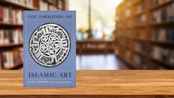 كتاب "تشكيل الفن الإسلامي" لأوليغ غرابر، إصدار منقح وموسع، موضوعة على طاولة خشبية في مكتبة مع خلفية من الرفوف المليئة بالكتب.