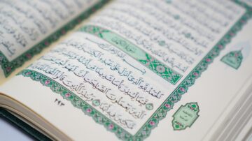 صفحة من القرآن الكريم، تظهر نصوصًا عربية مزخرفة بتفاصيل دقيقة وألوان زاهية. تتضمن الآيات تفسيرات دينية ومعاني عميقة، مع إطار مزخرف يضيف جمالًا للصفحة.