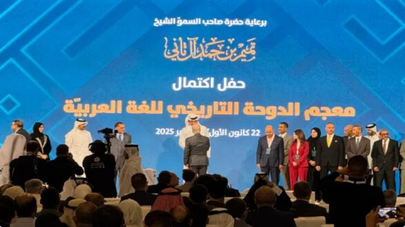 احتفال بإكمال معجم الدولة التاريخي للغة العربية، بحضور شخصيات بارزة في مجال الثقافة واللغة، مع خلفية زرقاء مزخرفة.