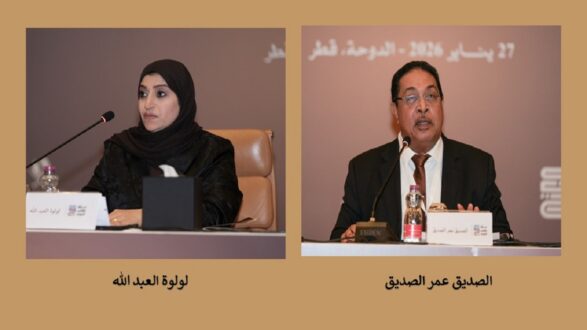 امرأة ترتدي عباءة سوداء تتحدث في مؤتمر، ورجل يرتدي بدلة رسمية يجلس بجانبها، كلاهما يشاركان في حدث رسمي في الدوحة، قطر، 27 يناير 2016.