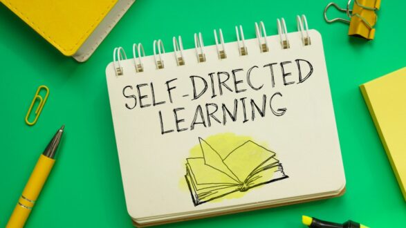 دفتر ملاحظات على خلفية خضراء، يحتوي على نص "التعلم الذاتي" مكتوب بخط بارز، مع رسم توضيحي لكتاب مفتوح، وأدوات مكتبية مثل قلم وورقة ملونة.