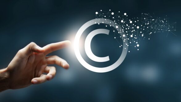 إصبع يلمس رمز حقوق الطبع والنشر مع تأثيرات ضوئية وخلفية داكنة، يرمز إلى الابتكار وحماية الملكية الفكرية.
