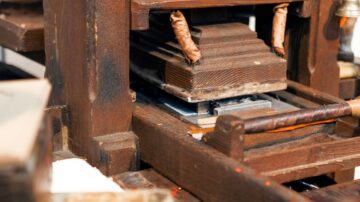 آلة طباعة قديمة مصنوعة من الخشب، تظهر تفاصيل الأجزاء المتحركة والألواح المستخدمة في الطباعة. التصميم يعكس الحرفية التقليدية، مع التركيز على المكونات الأساسية.