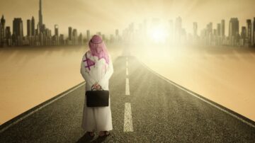 Person in traditional attire standing on a road in a desert landscape, facing a city skyline at sunrise. The scene conveys themes of ambition, journey, and hope.