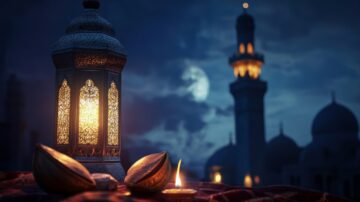 A beautifully crafted lantern emits a warm glow against a twilight sky, with a mosque silhouette in the background. The scene features ornate details on the lantern and a lit candle beside large nuts, creating a serene and inviting atmosphere.