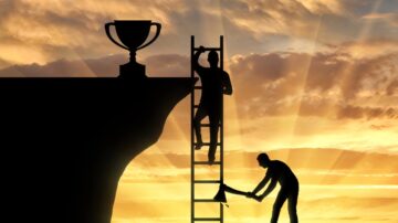 Silhouetted figures climbing a ladder towards a trophy on a cliff, with one figure chopping wood at the base, symbolizing hard work and achievement against a sunset backdrop.