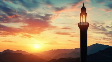 Silhouette of a minaret against a vibrant sunset sky, with mountains in the background. The scene features colorful clouds and a warm glow from the sun, creating a serene and picturesque atmosphere.