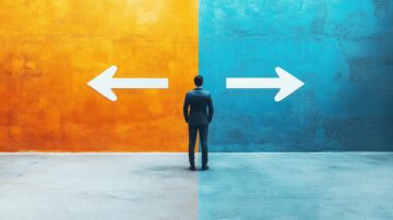 رجل يرتدي بدلة يقف أمام جدارين ملونين، أحدهما برتقالي والآخر أزرق، مع سهام تشير إلى اليمين واليسار، مما يرمز إلى اتخاذ القرارات والاختيارات.
