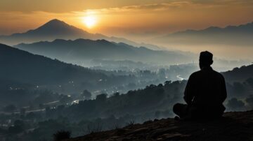 رجل يجلس في هدوء على قمة تل، يتأمل منظر غروب الشمس فوق الجبال. الأفق مليء بالضباب، مما يخلق جوًا سلميًا. يضيء الضوء الخافت المدينة أسفل الجبل، مع تفاصيل طبيعية واضحة في المقدمة.